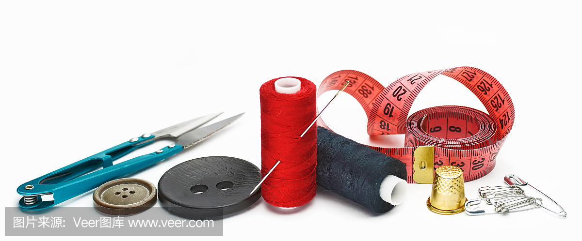 缝纫用品和配件。白色背景上的布料、线轴、剪刀和顶针。